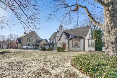 a house with a car parked in the driveway at Historic Auburn Home with Theater and Yard! in Auburn