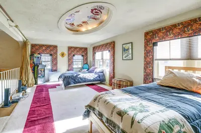 a bedroom with two beds and a large window at Historic Auburn Home with Theater and Yard! in Auburn