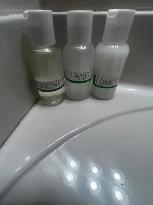 three bottles of moisturizers sitting on top of a bathroom sink at Home sweet home in Columbus