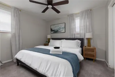 a bedroom with a large bed with a ceiling fan at Maple Heights Gem Libby Unit 1 in Maple Heights