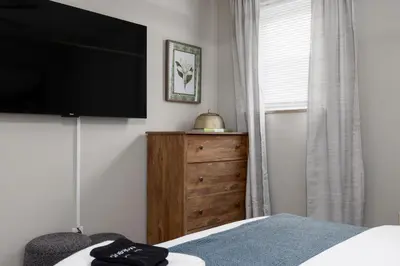 a bedroom with a flat screen tv and a dresser at Maple Heights Gem Libby Unit 1 in Maple Heights