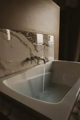 a bath tub with water pouring from a faucet at The Atlee Suites in Millersburg