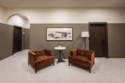 a lobby with two chairs and a table and a picture at The Atlee Suites in Millersburg