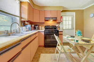 a kitchen with orange cabinets and a sink and a table at Cincinnati Home Rental with Balcony and Fire Pit! in Cincinnati