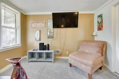 a living room with a chair and a flat screen tv at Cincinnati Home Rental with Balcony and Fire Pit! in Cincinnati