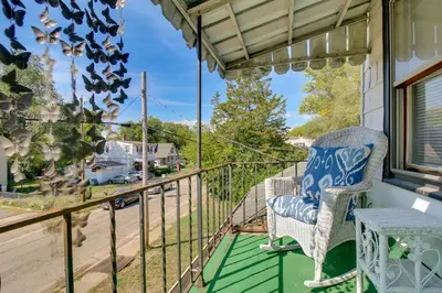 a balcony with a chair and a view of a street at Cincinnati Home Rental with Balcony and Fire Pit! in Cincinnati