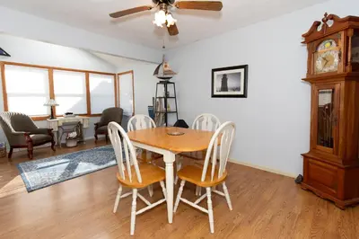 a dining room with a table and chairs and a clock at Bluebirds Road to Happiness in Vermilion