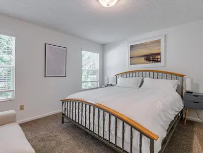 a bedroom with a large bed and two windows at Upscale Home near Blossom, CVNP, Ski Resorts in Cuyahoga Falls