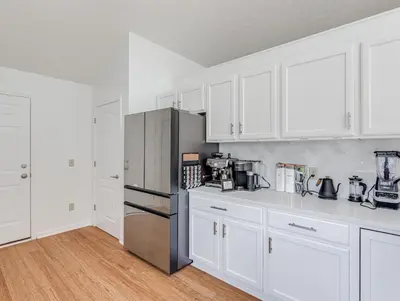 a kitchen with white cabinets and a stainless steel refrigerator at Upscale Home near Blossom, CVNP, Ski Resorts in Cuyahoga Falls
