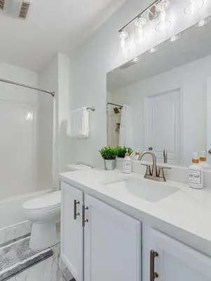 a white bathroom with a sink and a toilet at Upscale Home near Blossom, CVNP, Ski Resorts in Cuyahoga Falls
