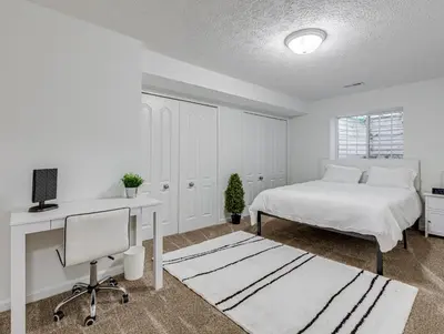 a white bedroom with a bed and a desk at Upscale Home near Blossom, CVNP, Ski Resorts in Cuyahoga Falls
