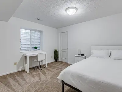 a bedroom with a bed and a desk and a window at Upscale Home near Blossom, CVNP, Ski Resorts in Cuyahoga Falls