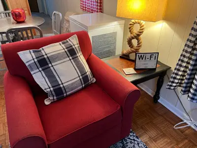 a red couch with a plaid pillow on a table at White Caps Motel and RV Park in Port Clinton