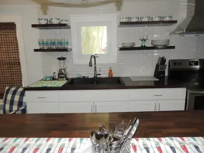 a kitchen with white cabinets and a sink at White Caps Motel and RV Park in Port Clinton