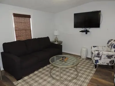 a living room with a black couch and a table at White Caps Motel and RV Park in Port Clinton