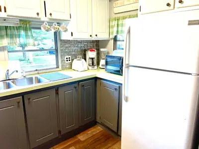 a kitchen with a white refrigerator and a sink at White Caps Motel and RV Park in Port Clinton
