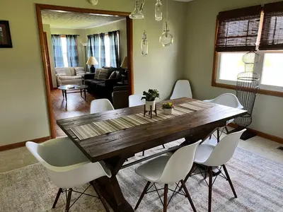a dining room with a wooden table and white chairs at White Caps Motel and RV Park in Port Clinton