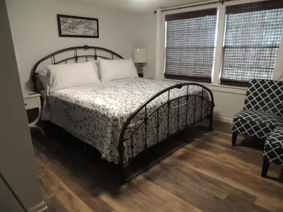 a bedroom with a bed and a chair and two windows at White Caps Motel and RV Park in Port Clinton