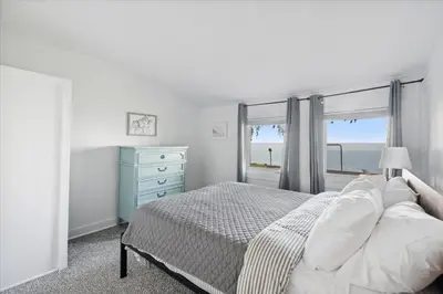 a bedroom with a bed with a view of the ocean at Lakefront Family Home/Golf Cart/Beach in Luna Pier