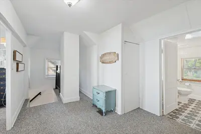 a white bathroom with a toilet and a television at Lakefront Family Home/Golf Cart/Beach in Luna Pier
