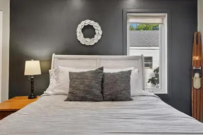 a bedroom with a large white bed with a window at Lakefront Family Home/Golf Cart/Beach in Luna Pier