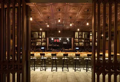 a bar with bar stools in a room at Metropolitan at The 9, Autograph Collection in Cleveland