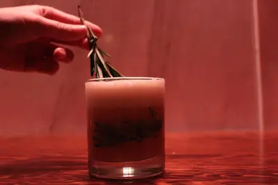 a person holding a pair of scissors in a drink at Metropolitan at The 9, Autograph Collection in Cleveland