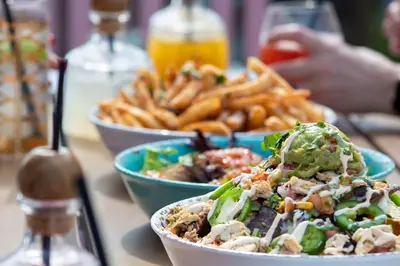 a table with two bowls of food and french fries at Metropolitan at The 9, Autograph Collection in Cleveland