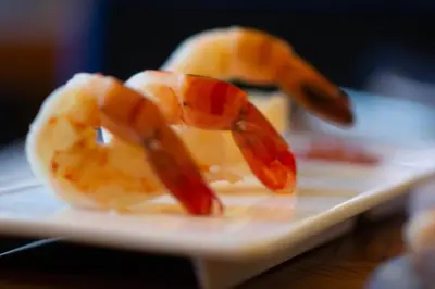 a plate of food with peeled shrimp on a table at Metropolitan at The 9, Autograph Collection in Cleveland