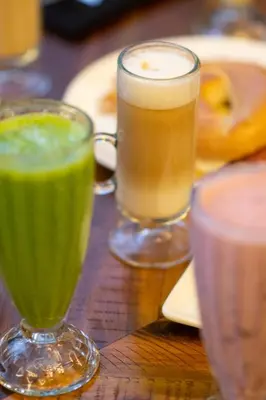 two glasses of green drinks on a wooden table at Metropolitan at The 9, Autograph Collection in Cleveland