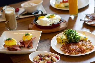 a wooden table with plates of breakfast food on it at Metropolitan at The 9, Autograph Collection in Cleveland
