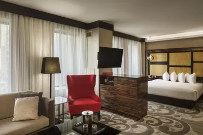 a hotel room with a bed and a red chair at Metropolitan at The 9, Autograph Collection in Cleveland