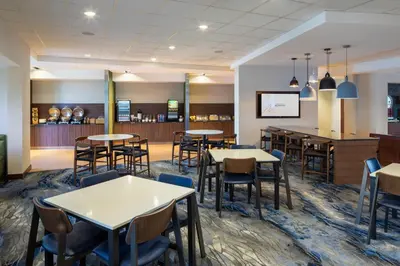 a restaurant with tables and chairs and a bar at Fairfield Inn & Suites by Marriott Columbus Airport in Columbus