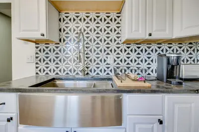 a kitchen with a sink and a tile wall at Jetted Tub Dayton Condo, 2 Mi to Oregon District in Dayton