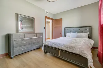 a bedroom with a large bed and a dresser at Jetted Tub Dayton Condo, 2 Mi to Oregon District in Dayton