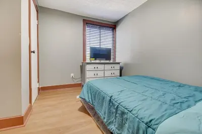 a bedroom with a bed and a dresser and a window at Jetted Tub Dayton Condo, 2 Mi to Oregon District in Dayton