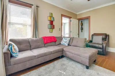 a living room with a brown couch and two chairs at Sunny and Spacious Dayton Condo about 1 Mi to Downtown! in Dayton