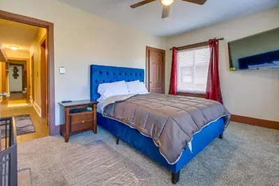 a bedroom with a blue bed and a television at Sunny and Spacious Dayton Condo about 1 Mi to Downtown! in Dayton