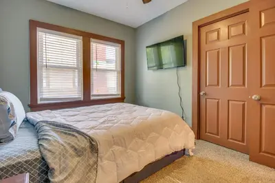 a bedroom with a bed and a window and a door at Sunny and Spacious Dayton Condo about 1 Mi to Downtown! in Dayton