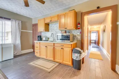 a kitchen with wooden cabinets and a trash can at Sunny and Spacious Dayton Condo about 1 Mi to Downtown! in Dayton