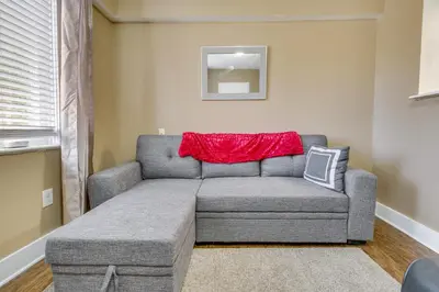a living room with a gray couch and a red blanket at Convenient Dayton Vacation Rental Near Downtown! in Dayton