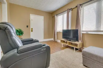 a living room with a leather chair and a flat screen tv at Convenient Dayton Vacation Rental Near Downtown! in Dayton