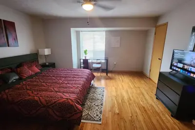 a bedroom with a bed and a flat screen tv at Tastefully Furnished 3bd @Euclid in Euclid