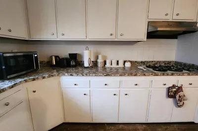 a kitchen with white cabinets and a granite counter top at Tastefully Furnished 3bd @Euclid in Euclid