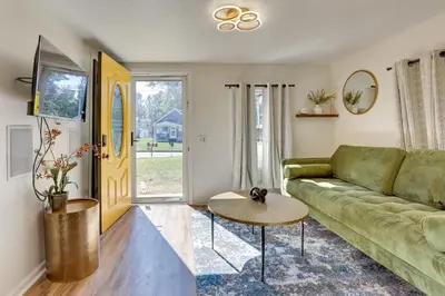 a living room with a green couch and a table at Modern Northfield Cottage with Yard! in Northfield