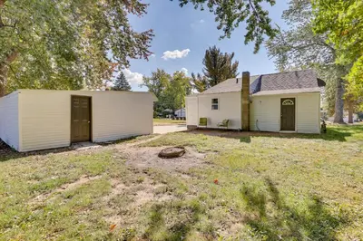 a white house with a garage in a yard at Modern Northfield Cottage with Yard! in Northfield