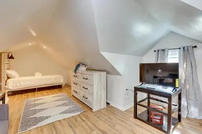 a bedroom with a bed and a dresser and a television at Modern Northfield Cottage with Yard! in Northfield