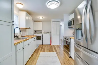 a kitchen with white cabinets and a refrigerator at Hillsboro Hideaway with Private Hot Tub and Bunkhouse! in Hillsboro