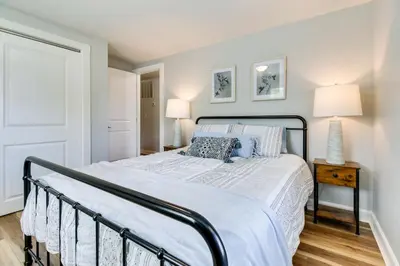 a bedroom with a large bed with a black frame at Hillsboro Hideaway with Private Hot Tub and Bunkhouse! in Hillsboro