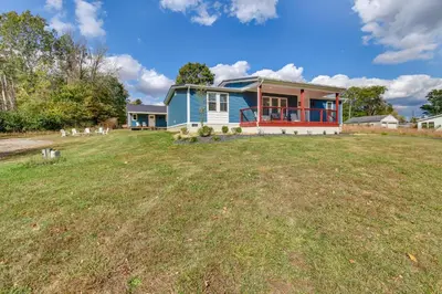 a blue house on a field with a yard at Hillsboro Hideaway with Private Hot Tub and Bunkhouse! in Hillsboro